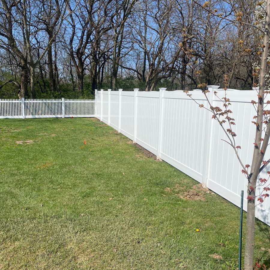 White vinyl privacy fence along a green lawn